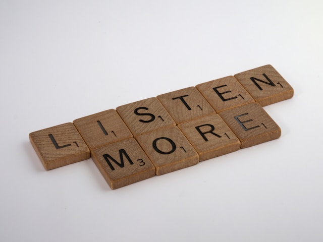 scrabble letters spelling out 'listen more'