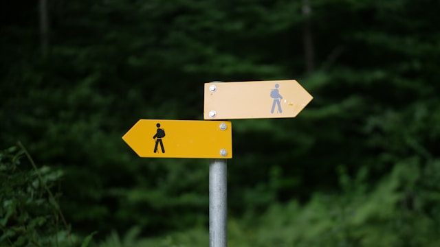 a signpost with two signs showing walkers