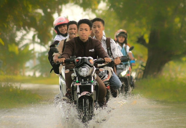 Group of motorbikes going through water in close order