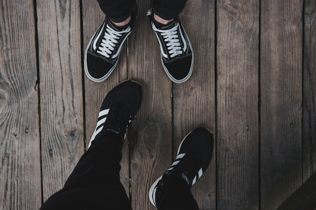 two people's shoes on a deck
