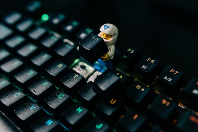 Lego minifig putting a key on the keyboard back in place.