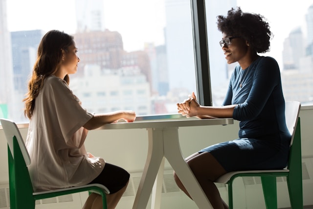 two people seated at a table across from each other 