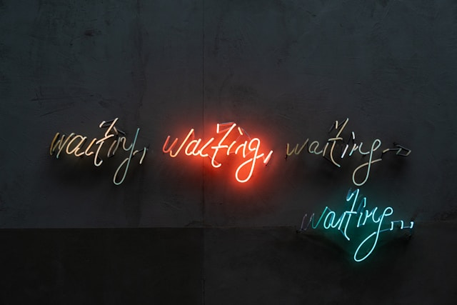 neon lights saying 'waiting, waiting, waiting, waiting'