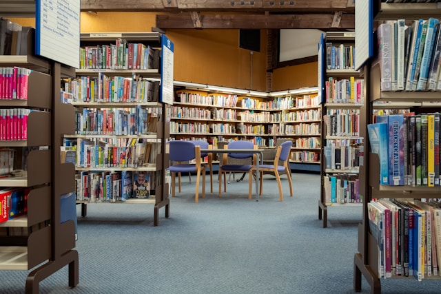 A library interior with bookshelves and a table with chairs