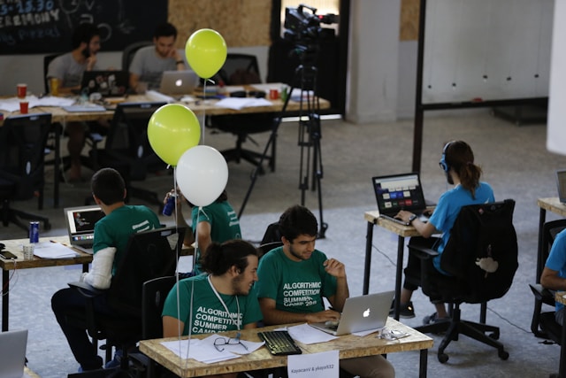 people sitting at desks with laptops working