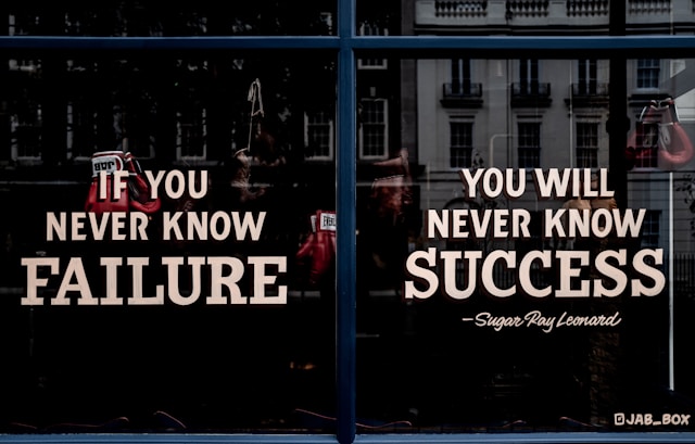 shop window text: 'if you never know failure, you will never know success' attributed to Sugar Ray Leonard
