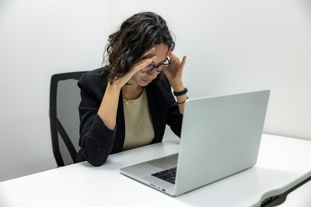person staring at laptop with their head in their hands